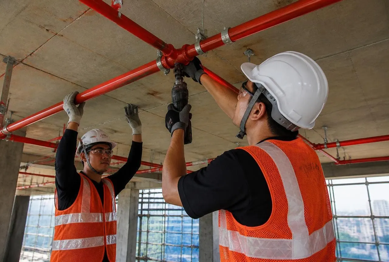 Axis Fire India technicians installing fire protection pipework on an active project site